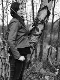 Portrait of woman standing by tree