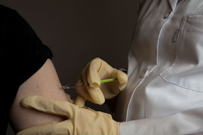 Midsection of male doctor injecting patient