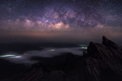 Scenic view of rocky mountains against star field sky at night