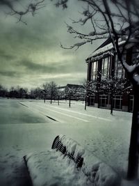 Snow covered landscape against cloudy sky