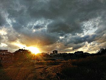 Silhouette of landscape against cloudy sky at sunset