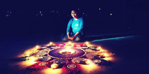 Man with illuminated light painting at night