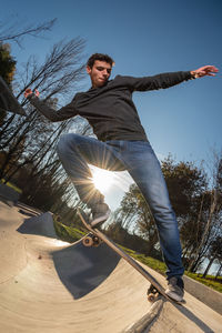Low angle view of young man standing against sky