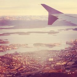 Aerial view of airplane wing over cityscape