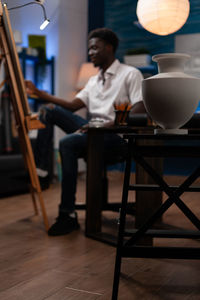 Rear view of man using digital tablet in cafe