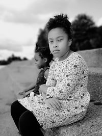 Portrait of girl sitting with sister on steps