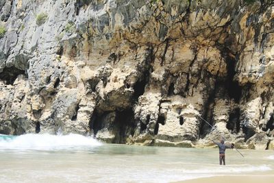 People standing on rock formation in cave