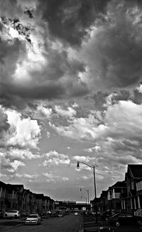 Traffic on road against cloudy sky