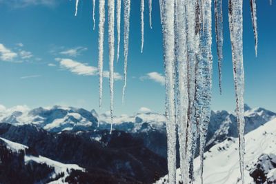 Scenic view of snow covered mountains against blue sky