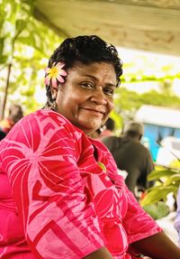 Portrait of mature woman smiling while sitting outdoors