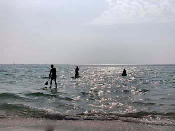 People on beach against sky
