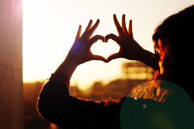 Silhouette of woman against sky during sunset