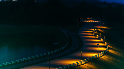 High angle view of illuminated road by lake