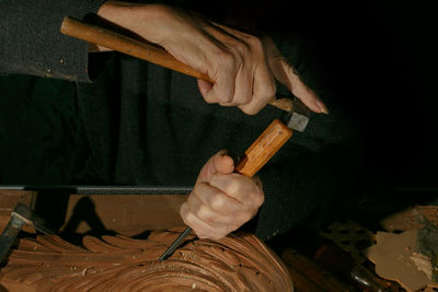 Craftsman's hands working on wood carving, with gouge and chisel cabinetmaker, carpentry