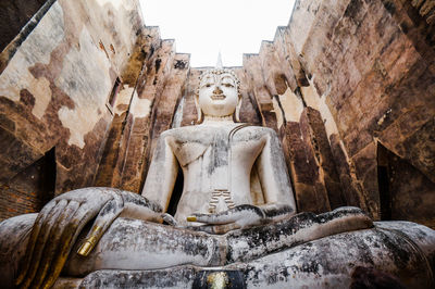 Statue of buddha against buildings