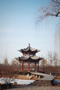 Built structure by trees against clear sky