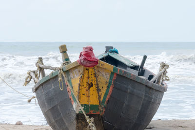 Nautical vessel on beach against clear sky