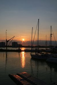 Silhouette of boats at harbor during sunset