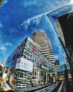 Low angle view of skyscrapers against cloudy sky