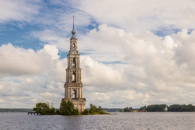 Tower of building against cloudy sky