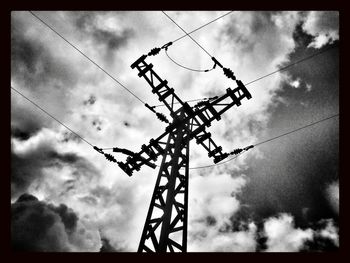 Low angle view of power lines against cloudy sky