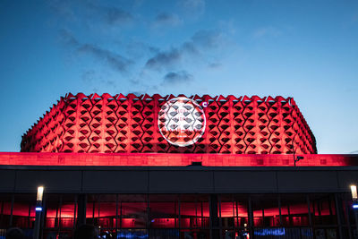 Low angle view of illuminated building against cloudy sky