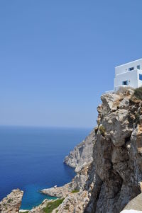 Scenic view of sea by buildings against clear blue sky