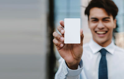 Portrait of smiling young man using mobile phone