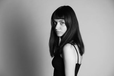 Portrait of beautiful young woman against white background