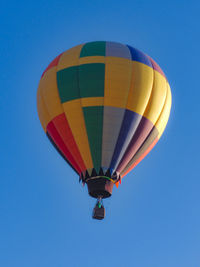 Low angle view of hot air balloon against clear blue sky