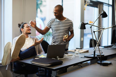 Creative businessmen greeting each other at desk in creative office