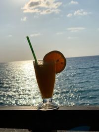 Close-up of beer in sea against sky