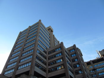 Low angle view of modern building against clear blue sky