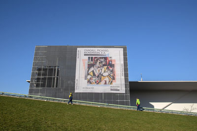 Graffiti on built structure against clear blue sky