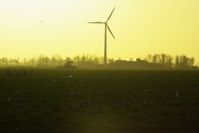 Wind turbine against sky during sunset