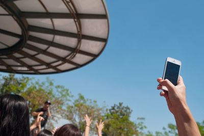 Cropped image of woman photographing through smart phone