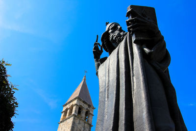 Low angle view of statue against blue sky