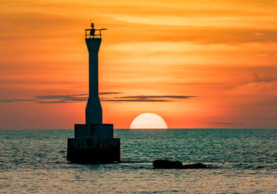 Silhouette of lighthouse at sunset