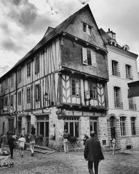 Rear view of man walking against building