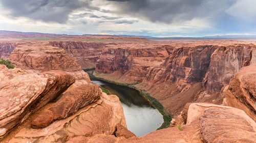 Scenic view of rock formations against cloudy sky