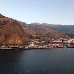 Scenic view of sea by townscape against clear sky