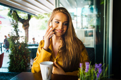 Portrait of smiling woman holding drink at restaurant