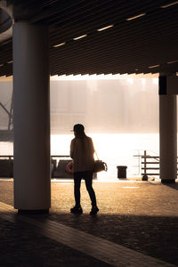Rear view of silhouette man standing on escalator