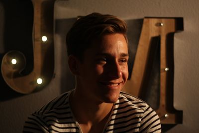 Close-up of smiling teenage boy against alphabets