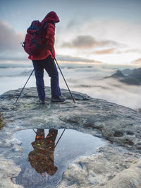 Full length of man standing on shore against sky