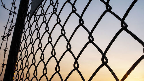 Low angle view of chainlink fence against sky