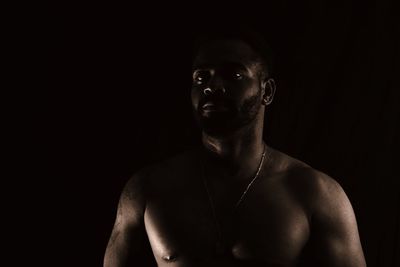 Portrait of young man against black background