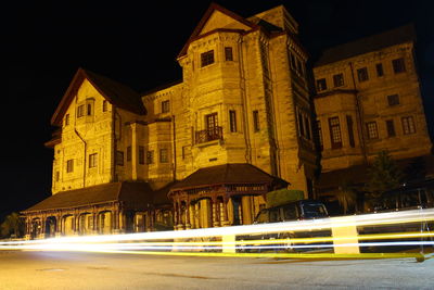 Illuminated buildings by street in city at night