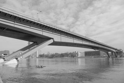 Bridge over river in city against sky