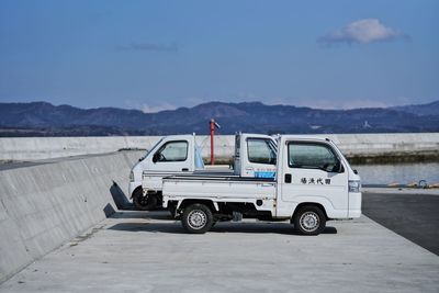 Vintage car on road against mountain range